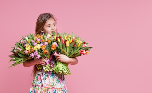 Linda niña sonriente niño sosteniendo ramo de flores de primavera