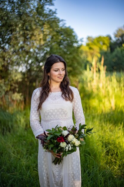 Linda noiva dia do casamento ao ar livre feliz recém-casada com buquê de flores de casamento