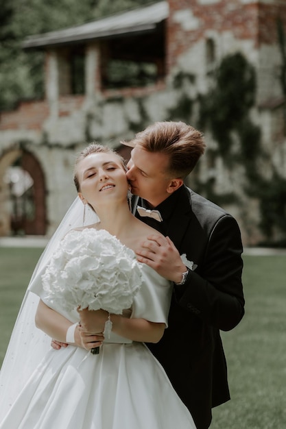 Linda noiva e noivo abraçando e beijando no dia do casamento ao ar livre