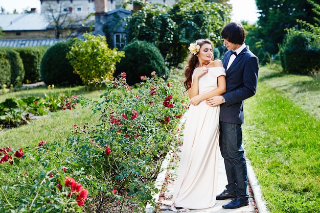 Linda noiva e noivo em pé perto um do outro no fundo do parque, foto de casamento, lindo casal.