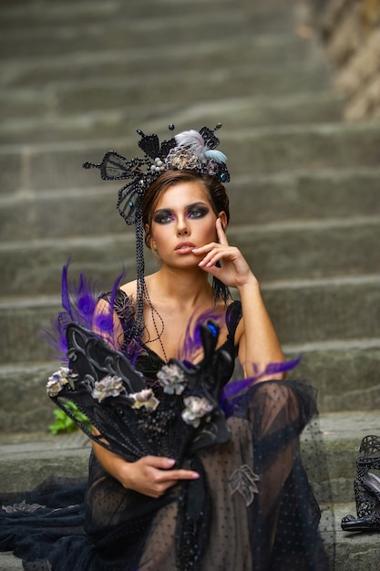 Linda noiva elegante em um vestido preto senta-se na escada em florença, itália.