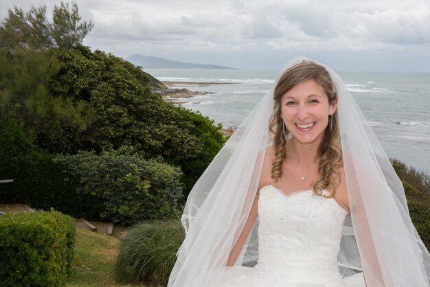 Linda noiva perto do oceano com vestido branco