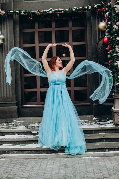 Linda noiva ruiva em um vestido longo azul no fundo da cidade