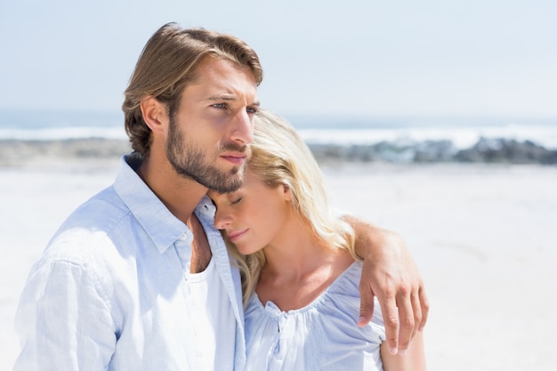 Linda pareja abrazándose en la playa