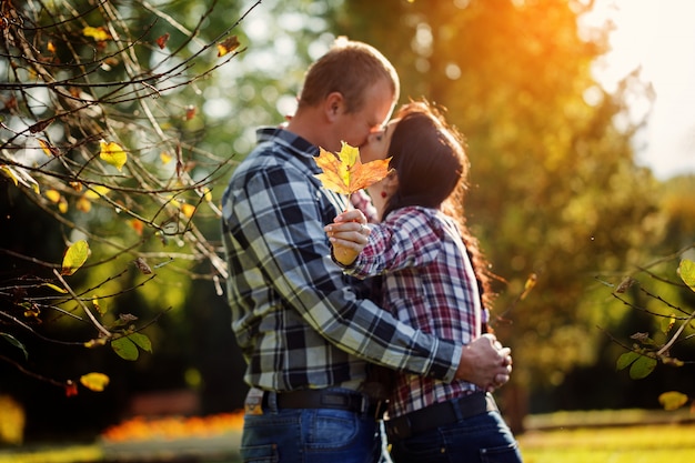 Linda pareja al aire libre en otoño. Joven y mujer besándose