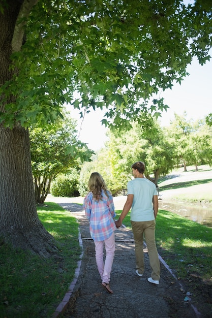 Linda pareja caminando de la mano en el parque