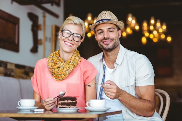 Linda pareja en una cita comiendo un pedazo de pastel de chocolate