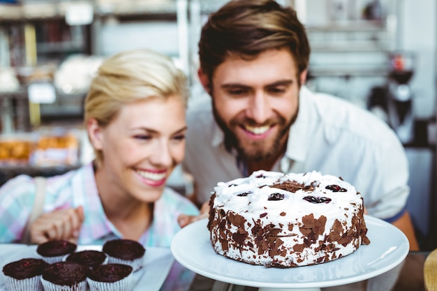 Linda pareja en una cita mirando un pastel de chocolate