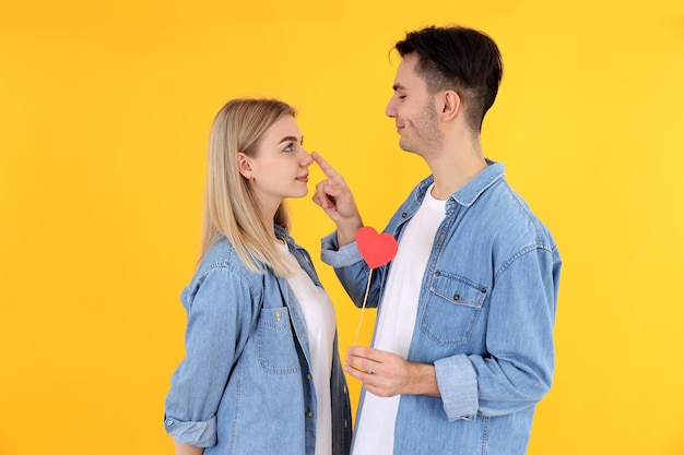 Linda pareja con corazón sobre fondo amarillo