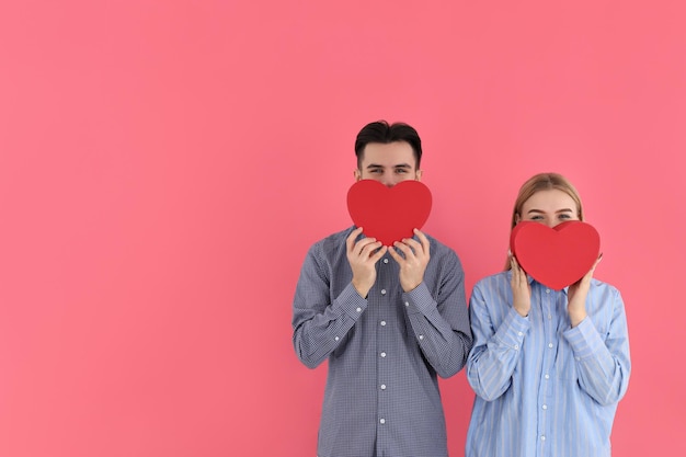 Linda pareja con corazones sobre fondo rosa