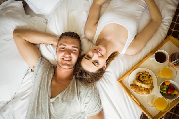 Linda pareja desayunando en la cama