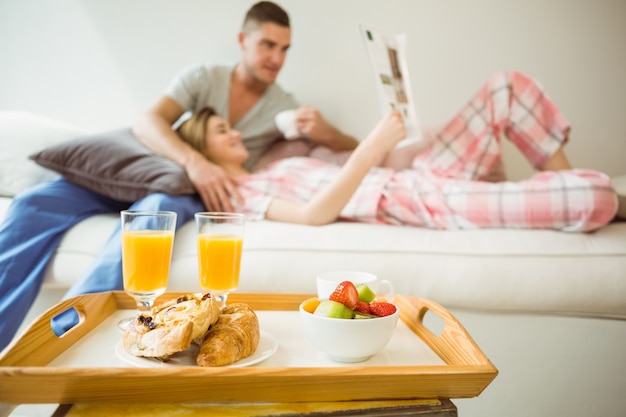 Linda pareja descansando en el sofá en el desayuno