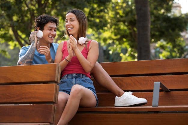 Foto linda pareja escuchando música con auriculares