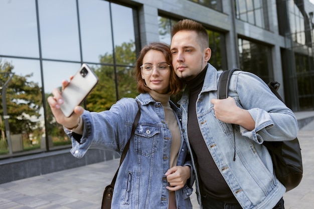 Linda pareja de estudiantes hipster tomando selfie en teléfono inteligente en la ciudad