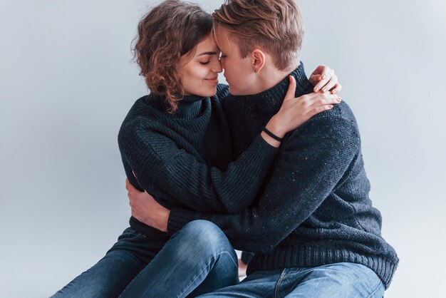 Linda pareja joven abrazándose unos a otros en el interior del estudio.