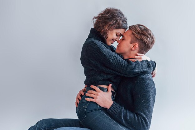 Linda pareja joven abrazándose unos a otros en el interior del estudio.