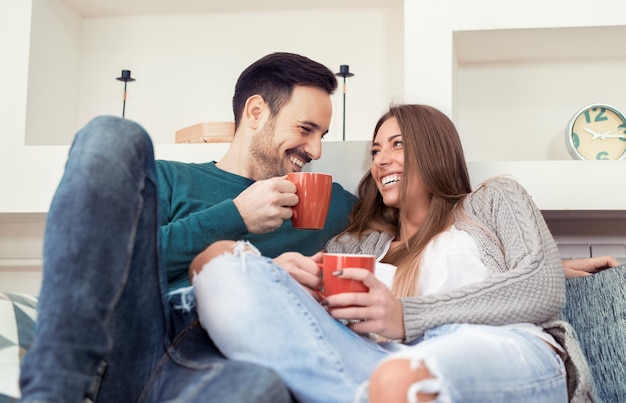 Linda pareja joven bebiendo café en casa