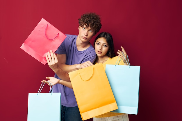 Linda pareja joven bolsas coloridas compras diversión aislado fondo inalterado