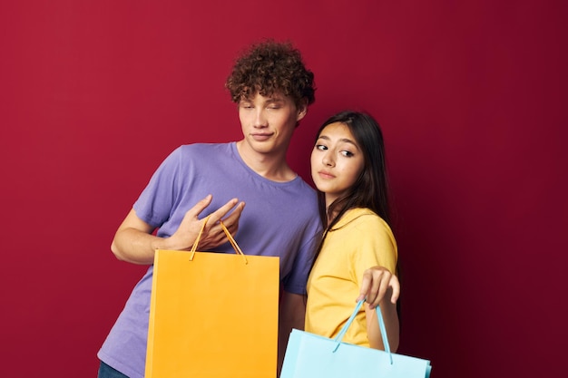 Linda pareja joven bolsas coloridas compras diversión aislado fondo inalterado