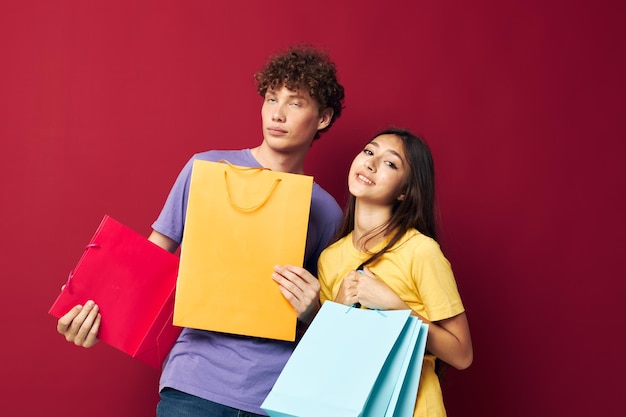 Linda pareja joven bolsas de compras en la mano fondo aislado inalterado