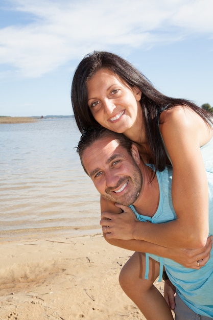 Foto linda pareja joven en playa de vacaciones superpuesto feliz y sonrisa