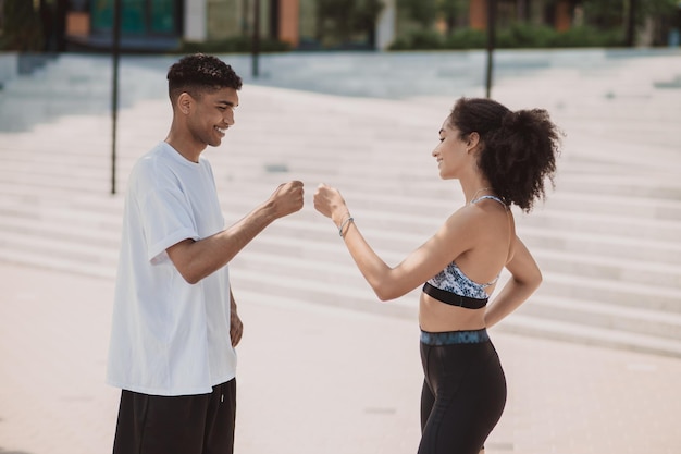 Linda pareja joven en ropa deportiva mirando alegre