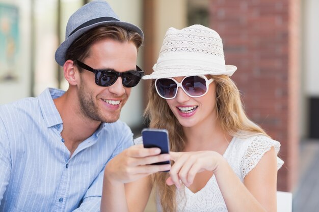 Linda pareja mirando un teléfono inteligente