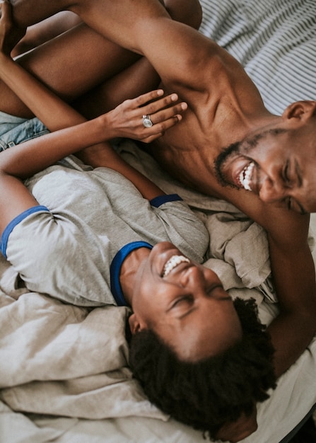 Linda pareja negra feliz jugando en la cama