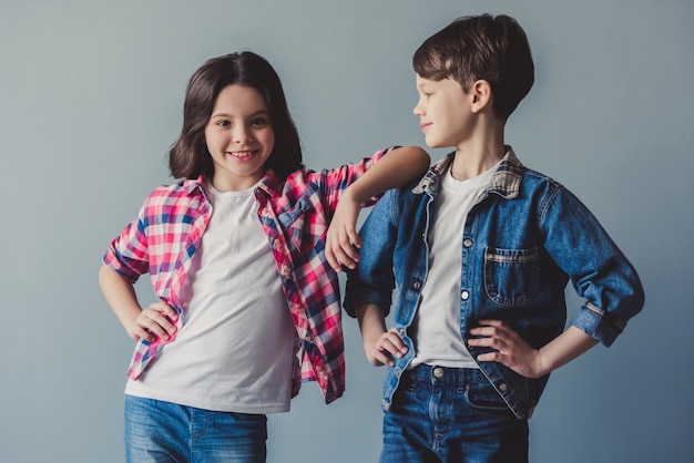 Foto linda pareja de niños en ropa casual están posando y sonriendo