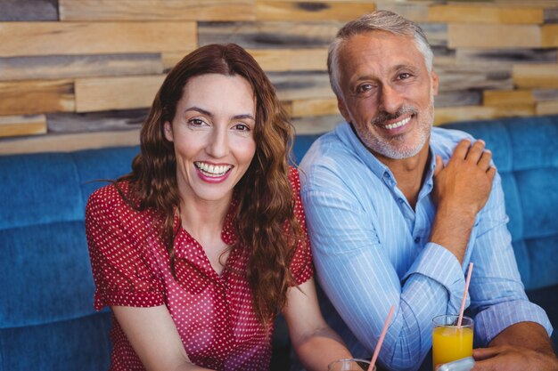 Foto linda pareja sentada en el café