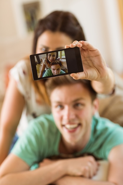 Linda pareja tomando un selfie en el sofá