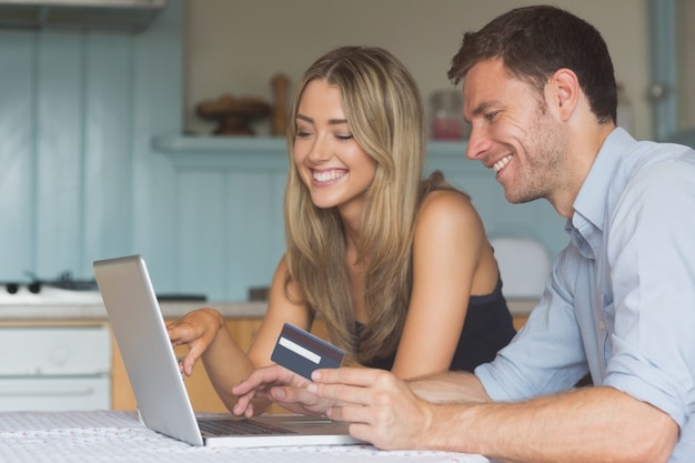 Linda pareja usando laptop juntos para comprar en línea