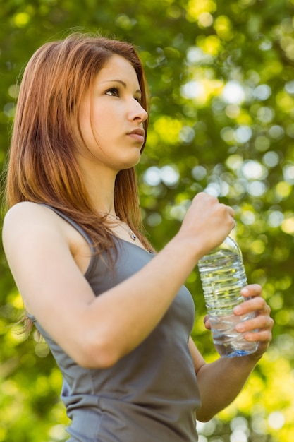 Linda pelirroja sosteniendo una botella de agua