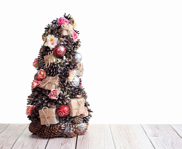 Linda pequena árvore de Natal na mesa de madeira com fundo branco