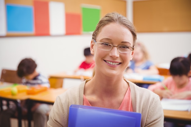 Linda professora sorrindo para a câmera enquanto segura a pasta