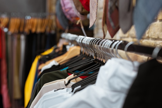 Linda ropa. Cerca de hermosas camisetas coloridas para hombres colgando y luciendo bien en una tienda de moda