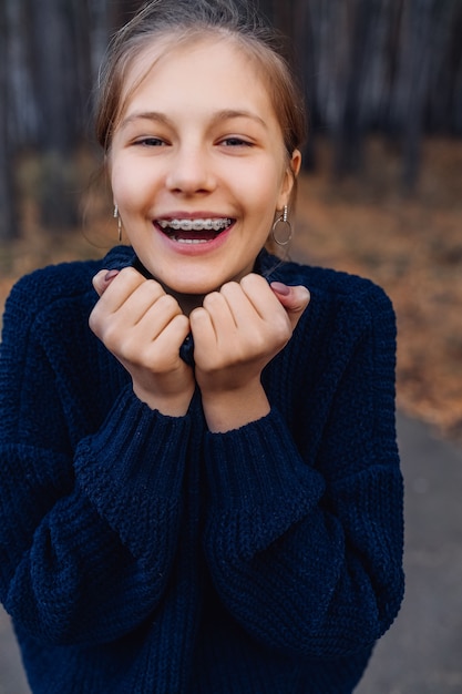 Linda rubia adolescente en el parque de otoño. Niña joven, posición, en, bosque