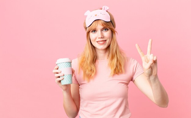 linda ruiva de pijama tomando um café