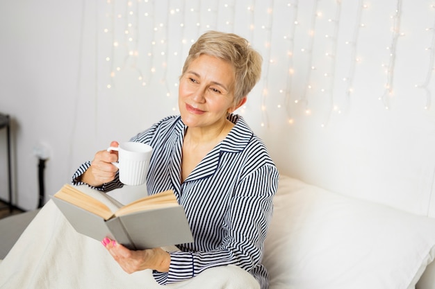 Linda senhora idosa de pijama na cama