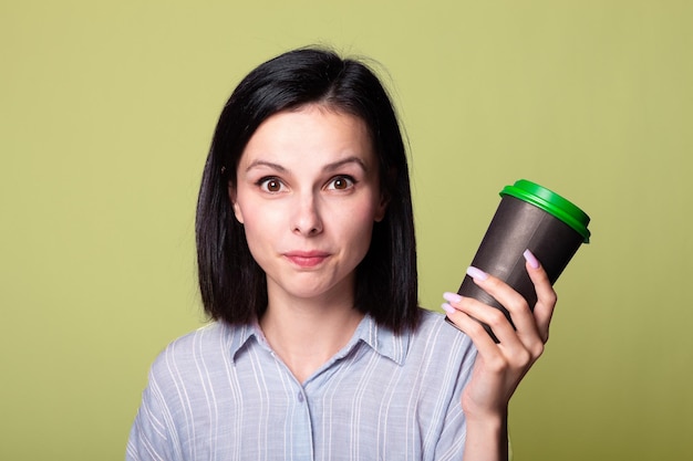 Linda senhora tem uma xícara de café nas mãos fundo verde