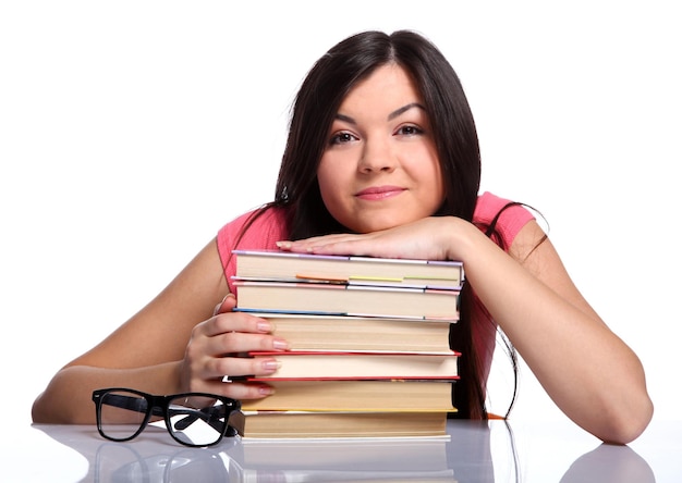 Linda universitária sentada perto dos óculos e segurando livros