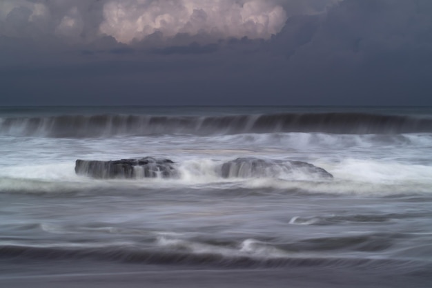 Linda vista matinal na Indonésia Panorama das ondas do mar e da praia