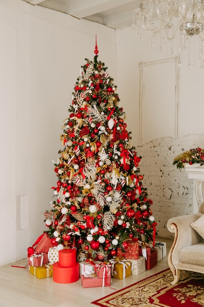 Lindamente decorada árvore de natal com muitos presentes debaixo dela