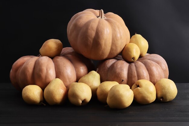 Lindas abóboras em um fundo preto de madeira. Peras em um fundo preto de madeira. Lay Flat. Abóboras de Halloween.