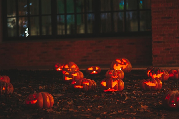 Lindas abóboras esculpidas com cara engraçada de brilho laranja para o feriado de Halloween à noite ao ar livre