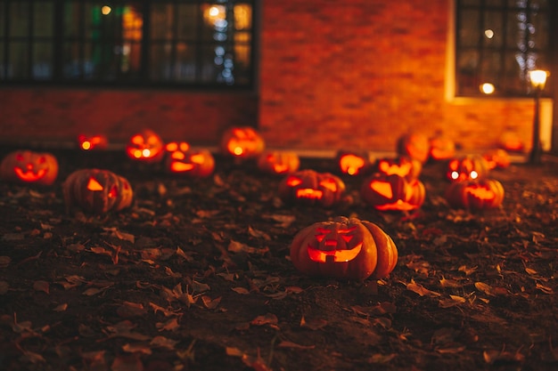 Lindas abóboras esculpidas com cara engraçada de brilho laranja para o feriado de Halloween à noite ao ar livre