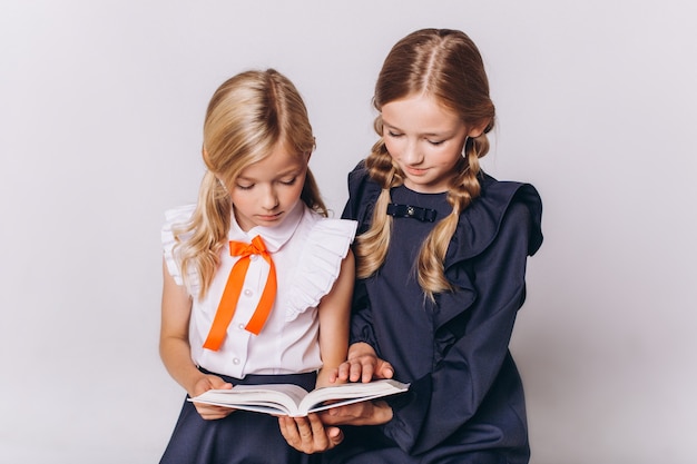 Lindas adorables niñas caucásicas blondie en uniforme escolar