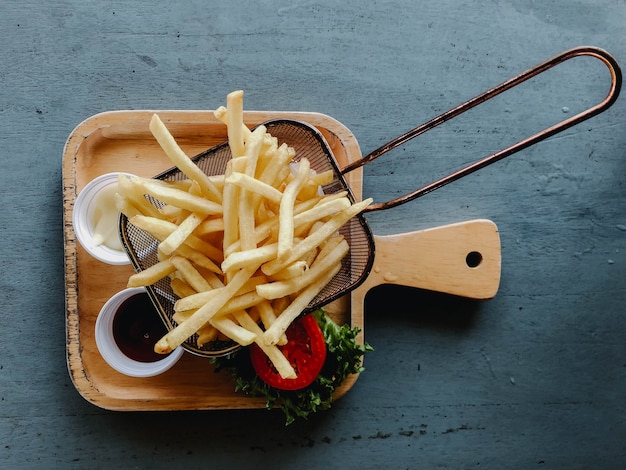 Lindas batatas fritas em uma mesa de madeira