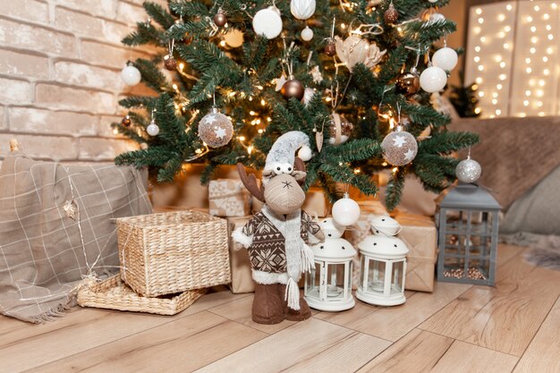 Lindas caixas de presente de Natal no chão perto de um pinheiro na sala