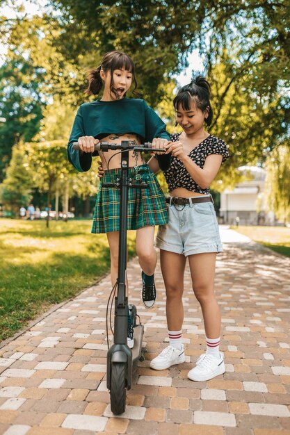 Foto lindas chicas jóvenes delgadas montando una moto en el parque